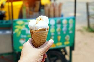 Homemade coconut ice cream topped with roasted peanuts Sweet and fragrant coconut milk in a cone. can be bought from street vendors selling ice cream at home. soft and selective focus. photo