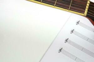 el acústico guitarra cuello y musical notas en blanco antecedentes. amar, música y aprendizaje concepto. foto