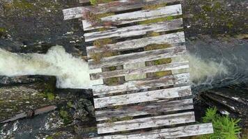 un vecchio traballante di legno ponte attraversamento un' piccolo fiume video