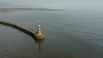 A Lighthouse and Pier at the Mouth of a Harbour video