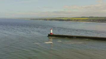 A Lighthouse and Breakwater at the Mouth of a Harbour in the UK video