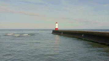 A Lighthouse and Breakwater at the Mouth of a Harbour in the UK video