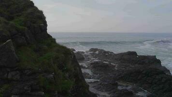 oceano ondas falhando contra a rochoso margens do a litoral video
