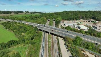 Commuter Train Speeding Under a Motorway in the UK Aerial View video