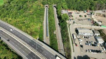 Commuter Train Speeding Under a Motorway in the UK Aerial View video