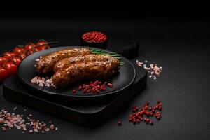 Delicious fried grilled sausages with salt, spices and herbs photo