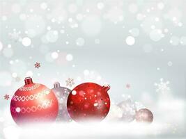 Realistic baubles on snowy bokeh effect background can be used as greeting card design. vector