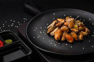 Delicious marinated mussels with spices and herbs on a ceramic plate photo