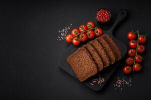 Delicious fresh brown bread with grains and seeds sliced on a wooden cutting board photo
