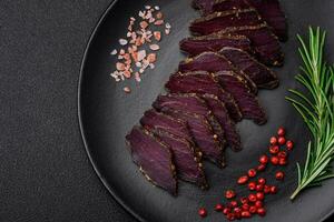 Delicious dried smoked beef or horse meat jerky with spices and salt photo