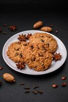 Delicious baked oatmeal raisin cookies on a dark concrete background photo