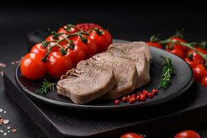 Delicious boiled beef tongue sliced with vegetables and spices photo