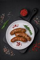 Delicious fried grilled sausages with salt, spices and herbs photo