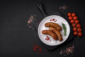 Delicious fried grilled sausages with salt, spices and herbs photo