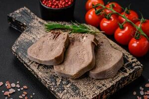 Delicious boiled beef tongue sliced with vegetables and spices photo