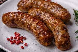 Delicious fried grilled sausages with salt, spices and herbs photo