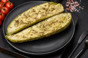 Delicious zucchini cut into two halves baked with salt, spices and herbs photo