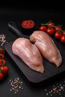 Pieces of raw chicken or turkey fillet with salt, spices and herbs photo