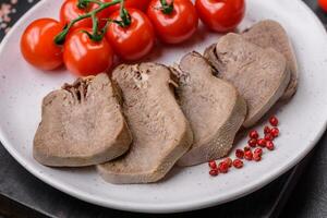 Delicious boiled beef tongue sliced with vegetables and spices photo