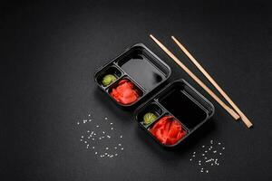 Pickled ginger, soy sauce and wasabi in portioned plastic containers photo