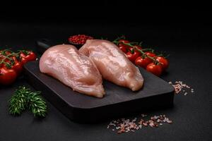 Pieces of raw chicken or turkey fillet with salt, spices and herbs photo