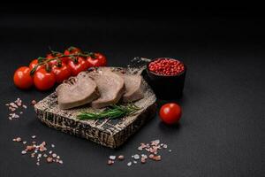 Delicious boiled beef tongue sliced with vegetables and spices photo