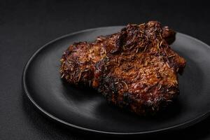 Delicious beef or pork steak on the bone grilled with spices and rosemary photo