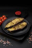 Delicious eggplant cut into two halves baked with salt, spices and herbs photo