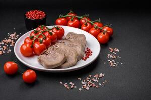 Delicious boiled beef tongue sliced with vegetables and spices photo