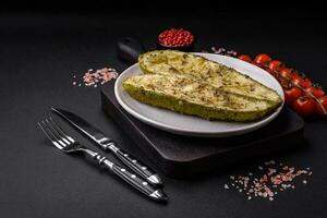 Delicious zucchini cut into two halves baked with salt, spices and herbs photo