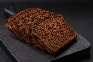 Delicious fresh brown bread with grains and seeds sliced on a wooden cutting board photo