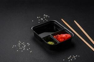 Pickled ginger, soy sauce and wasabi in portioned plastic containers photo