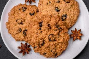 delicioso horneado harina de avena pasa galletas en un oscuro hormigón antecedentes foto