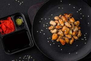 Delicious marinated mussels with spices and herbs on a ceramic plate photo