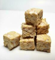 Pile of raw tempeh, dice cutting, On White Background. photo