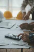 ingeniero de obra de construcción de dos hombres de negocios. objetos de ingeniería en el lugar de trabajo con socios que interactúan en segundo plano foto