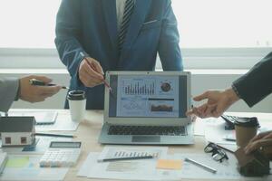 Group of confident business people point to graphs and charts to analyze market data, balance sheet, account, net profit to plan new sales strategies to increase production capacity. photo