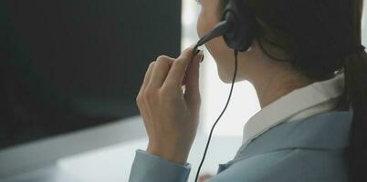 Young friendly operator woman agent with headsets working in a call centre. photo