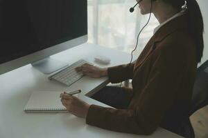 Young friendly operator woman agent with headsets working in a call centre. photo