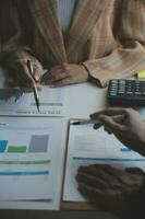 los analistas financieros analizan los informes financieros de negocios en un proyecto de inversión de planificación de tabletas digitales durante una discusión en una reunión de empresas que muestran los resultados de su exitoso trabajo en equipo. foto