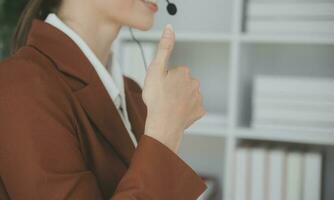 Young friendly operator woman agent with headsets working in a call centre. photo