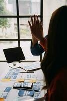 Close up ux developer and ui designer brainstorming about mobile app interface wireframe design on table with customer breif and color code at modern office.Creative digital development agency photo