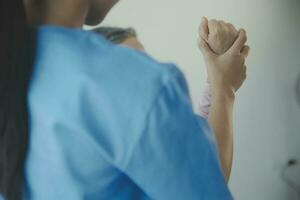 Doctor or physical therapist examines back pain and spinal area to give advice within the rehabilitation center. photo