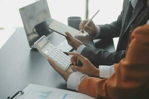 Group of confident business people point to graphs and charts to analyze market data, balance sheet, account, net profit to plan new sales strategies to increase production capacity. photo