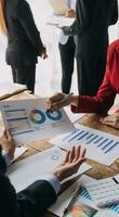 Financial analysts analyze business financial reports on a digital tablet planning investment project during a discussion at a meeting of corporate showing the results of their successful teamwork. photo