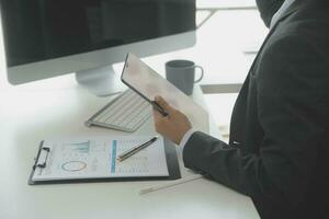 Group of confident business people point to graphs and charts to analyze market data, balance sheet, account, net profit to plan new sales strategies to increase production capacity. photo