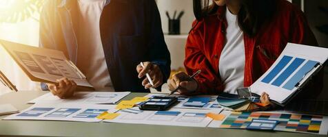 Close up ux developer and ui designer brainstorming about mobile app interface wireframe design on table with customer breif and color code at modern office.Creative digital development agency photo