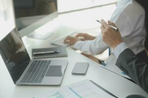 Group of confident business people point to graphs and charts to analyze market data, balance sheet, account, net profit to plan new sales strategies to increase production capacity. photo