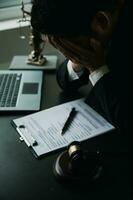 Business and lawyers discussing contract papers with brass scale on desk in office. Law, legal services, advice, justice and law concept picture with film grain effect photo