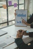 Financial analysts analyze business financial reports on a digital tablet planning investment project during a discussion at a meeting of corporate showing the results of their successful teamwork. photo